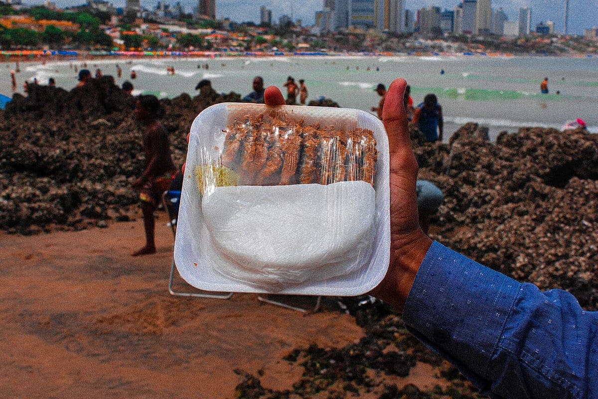 Ginga com tapioca servida numa bandeja, com a orla de Natal ao fundo